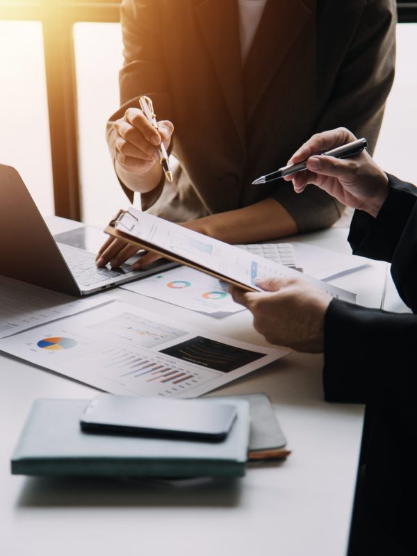 Financial analysts analyze business financial reports on a digital tablet planning investment project during a discussion at a meeting of corporate showing the results of their successful teamwork.